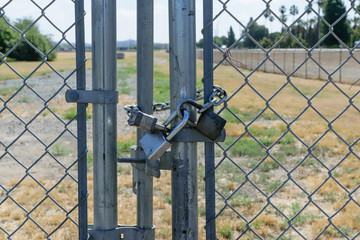 Three locks secure gate on fence
