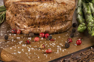 Close up on fillet mignon with asparagus on the side.