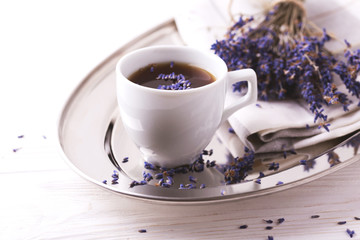 Cup of coffee with lavender flowers on table