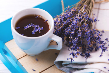 Cup of coffee with lavender flowers on table