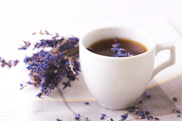Obraz na płótnie Canvas Cup of coffee with lavender flowers on table