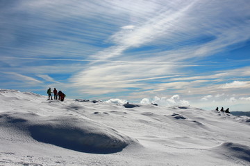 A pack of hikers walking down from Matagalls peak summit on a winter sunny day, Montseny mountains, Barcelona.