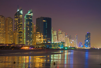 Fototapeta na wymiar Dubai - The nightly Marina towers from beach.