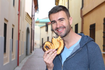 Man with healthy teeth holding a heart-shaped puff pastry 