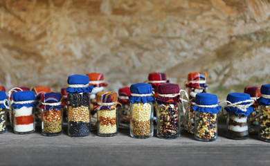 Beautiful jars with grains, cereals, legumes and seeds on wooden background