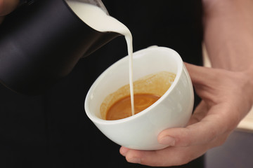 Man drawing on coffee with frothed milk