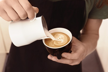 Man drawing on coffee with frothed milk