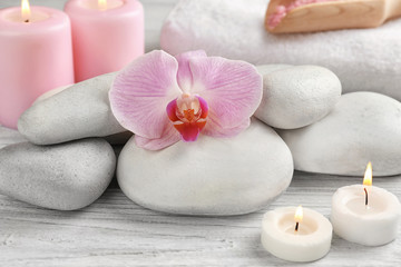 Spa stones with flower on wooden table