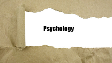 Torn brown paper on white surface with "Psychology" word.