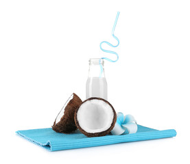 Bottle of coconut milk and fresh nut on white background