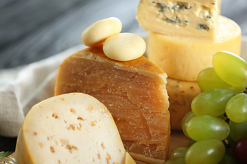 Different types of cheese and grapes, closeup