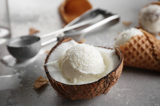 Fresh ball of ice cream in half of coconut on kitchen table