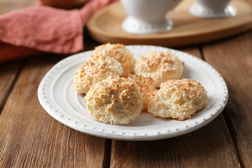 Plate with delicious coconut macaroons on table