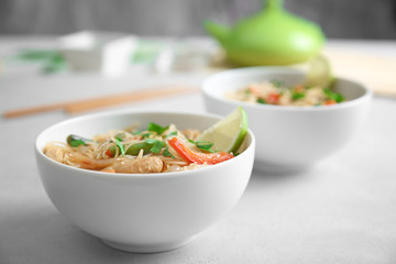 White plate with delicious rice noodle and vegetables against blurred background