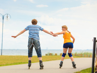 Young couple on roller skates riding outdoors