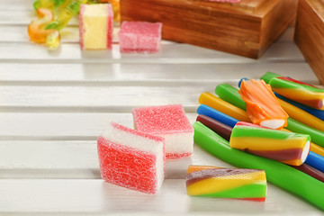 Composition of tasty jelly candies on wooden background