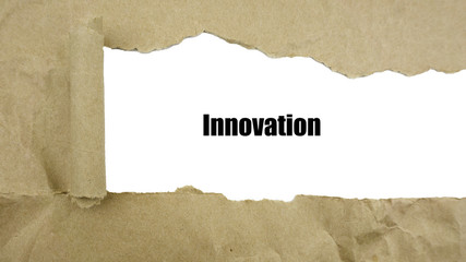 Torn brown paper on white surface with "innovation" word.