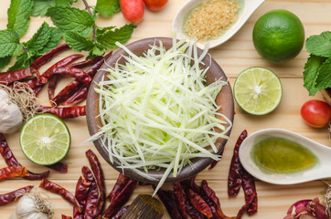 Ingredients for making papaya salad on a wooden table. Set of Thai spices and herbs