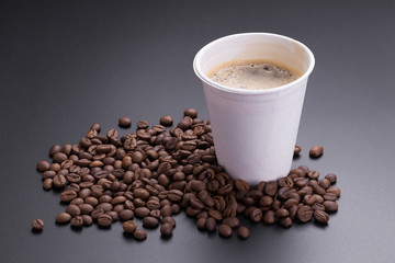 Hot americano coffee in paper cup of coffee and coffee beans on black background
