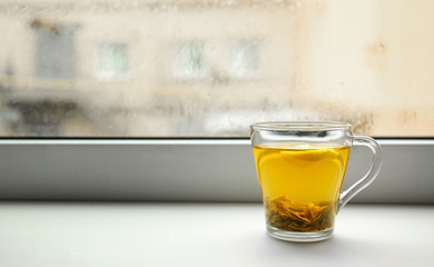 Cup of hot tea on window sill