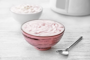 Bowl with yogurt on wooden table