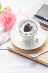 Notebooks, pen and chocolate cake in a cup with rose flower on white wooden background. flower on white wooden background.