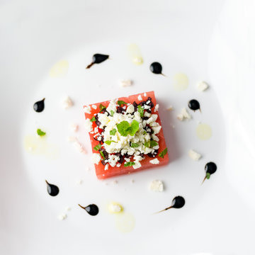 Watermelon feta top view.  This watermelon cubes salad is made with greek feta cheese crumbs, olive slices, mint, olive oil and balsamic vinegar. So refreshing, the perfect food for the summer!