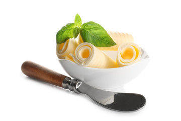 Delicious butter curls with basil leaves in bowl and shovel on white background, closeup