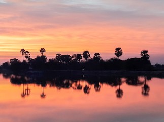 Fototapeta na wymiar sunsets behind the pond.