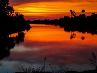 Obraz na płótnie Canvas sunsets behind the pond.