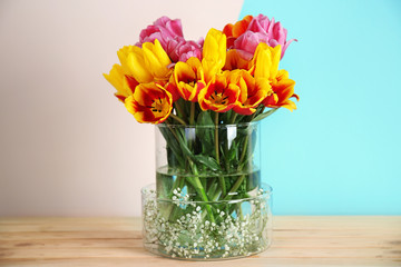 Vase with beautiful bouquet of spring flowers on wooden table
