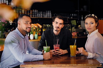 Friends drinking coctails in a cafe.