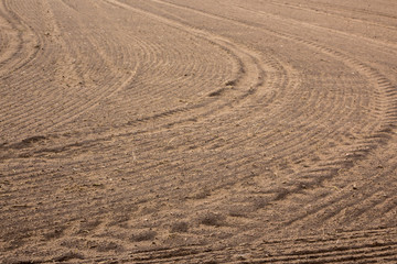 Plowed field. Drawing on the ground furrows and traces of tractor tires. Early Spring on Podlasie, Eastern Poland.