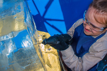 Girl of seven years in the master class on ice sculpture