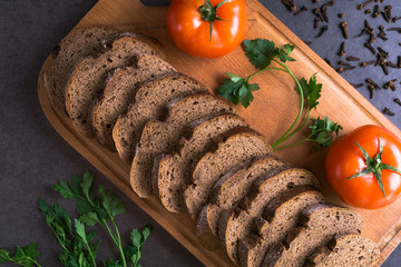 fresh tomatoes with homemade bread and greens, lie on the wooden Board