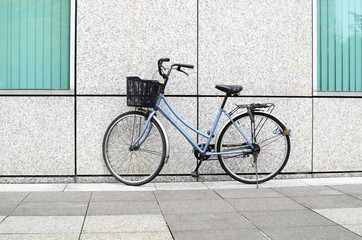 A blue bicycle parking in front of the wall.