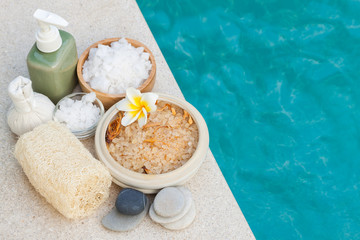 Salt scrub and spa objects at the side of swimming pool, beauty and wellnexx concept