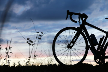 Fototapeta na wymiar bicycle silhouette on sunset in Summer 
