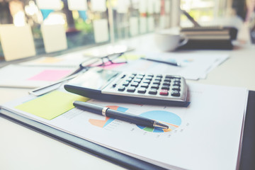 Business concept with copy space. Office desk table with pen focus and analysis chart computer notebook cup of coffee on desk.Vintage tone Retro filter effect. Selective focus.