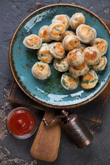 Above view of roasted russian meat dumplings or pelmeni on a dark brown stone background