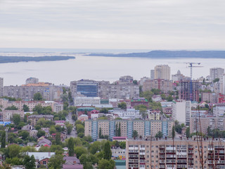 Naklejka premium The city's skyline. The Russian province of Saratov. High-rise residential buildings, the Volga river and the railway bridge on the horizon