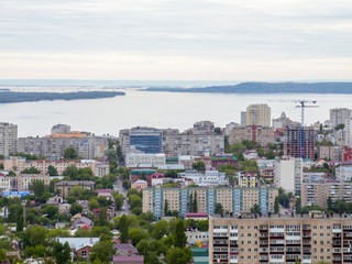 The city's skyline. The Russian province of Saratov. High-rise residential buildings, the Volga river and the railway bridge on the horizon