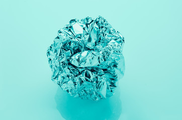 crumpled aluminum foil ball on plain background, filter effect, sweet tone