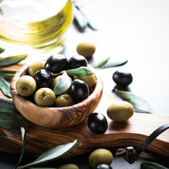 Black and green olives in wooden bowl