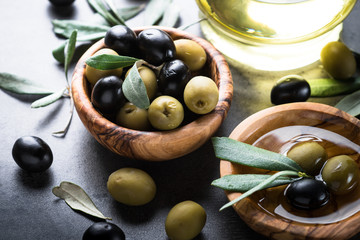 Black and green olives in wooden bowl