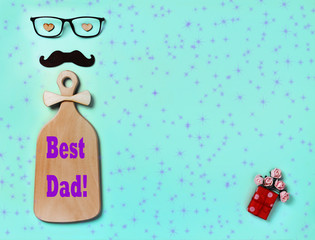 Postcard Best Dad. Glasses, mustache, homemade gift, flowers, bow tie on a blue background.