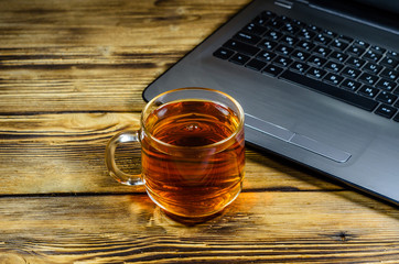 Laptop and cup of tea on wooden table