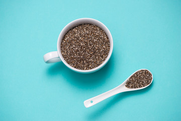 Cup of healthy chia seeds and spoon. Text space.