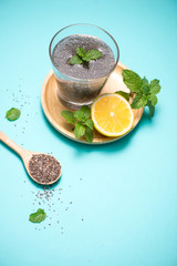 Selective focus of chia seeds drink with water in transparent glass with lemon balm.