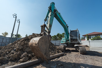 excavator on construction site, digger on gravel heap with shovel